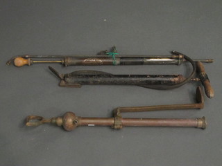A brass stirrup pump, a metal foot pump and a brass garden  syringe