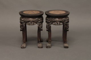 A pair of circular Oriental pierced and carved hardwood urn stands, the bases inset marble panels 10"