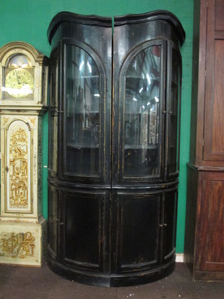 A handsome pair of 19th Century ebonised double corner  cabinets, the upper sections fitted shelves enclosed by glazed  panelled doors, the bases fitted a double cupboard enclosed by  panelled doors, each
