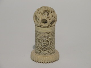 A carved ivory puzzle ball 1" raised on a pierced stand 2"  ILLUSTRATED