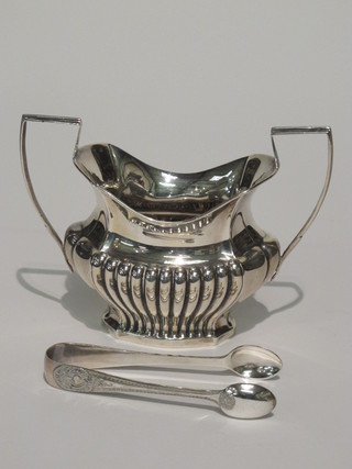 An Edwardian embossed oval silver twin handled sugar bowl  with demi-reeded decoration Chester 1901, 4 ozs and a pair of  silver plated sugar tongs