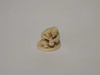 A carved ivory Netsuke of a seated gentleman, the base signed, 1  1/2"