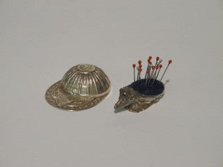 A modern silver caddy spoon in the form of a jockey cap together with a modern silver pin cushion in the form of a hedgehog