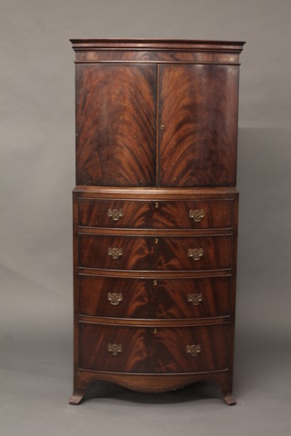 A Georgian style mahogany bow front cabinet on chest, the upper  section with moulded cornice fitted a cupboard enclosed by  panelled doors, the base fitted 4 long graduated drawers raised on  splayed bracket feet 28"