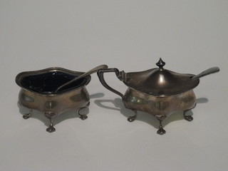 An oval shaped silver mustard pot and salt Sheffield 1902  complete with blue glass liners 3 1/2 ozs