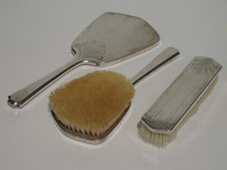 A Continental white metal 3 piece backed dressing table set with hand mirror, hairbrush and clothes brush