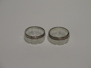 A pair of cut glass salts with silver rims
