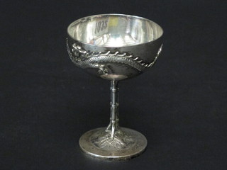 An Oriental embossed white metal pedestal bowl decorated a running dragon
