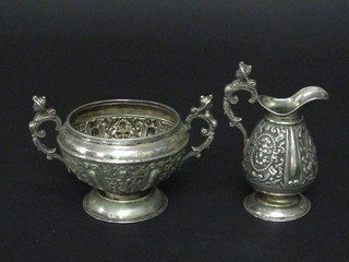 A Victorian embossed silver cream jug, London 1888 together  with a similar twin handled sugar bowl London 1889, 8 ozs