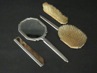 A 4 piece silver backed dressing table set with hand mirror,  hairbrush, clothes brush and comb with engine turned decoration