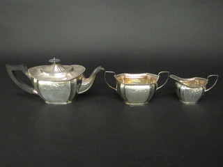 An oval engraved silver plated tea service with teapot, twin  handled sugar bowl and milk jug