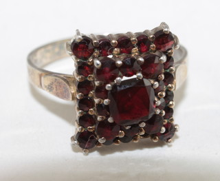 A gilt metal dress ring set red stones