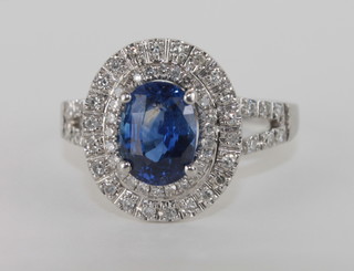 An 18ct white gold dress ring set a sapphire surrounded by  diamonds