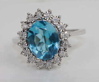 An 18ct white gold dress ring set an oval blue Topaz surrounded  by diamonds