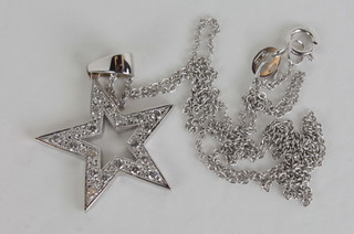 A pendant in the form of a 5 pointed star set diamonds hung on a  fine gold chain