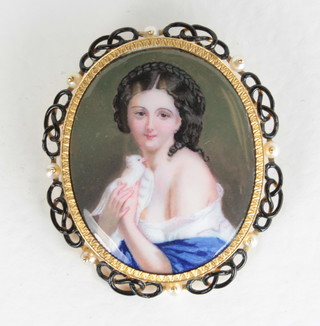 A handsome portrait miniature brooch of a seated girl with dove contained in a gilt metal mount  ILLUSTRATED