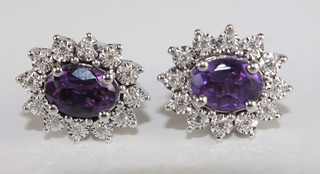 A pair 18ct gold earrings set amethyst surrounded by diamonds
