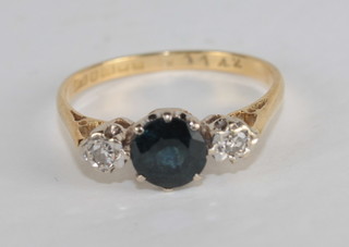 A lady's 18ct gold dress ring set a blue stone supported by 2  diamonds
