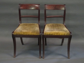 A set of 4 Regency style bar back dining chairs with rope edge  mid rails and upholstered drop in seats, raised on sabre supports
