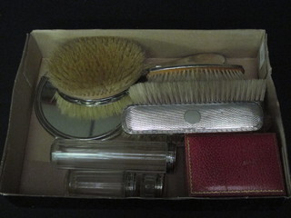 An oval silver and enamelled hairbrush, 2 silver backed hand mirrors, 4 silver backed clothes brushes, 3 glass dressing table  chairs with silver lids