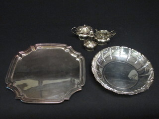 A square silver plated salver with bracketed border, a circular silver plated dish and a 3 piece silver plated condiment set