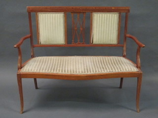 An Edwardian inlaid mahogany settee with upholstered seat and back, raised on tapering supports 45"