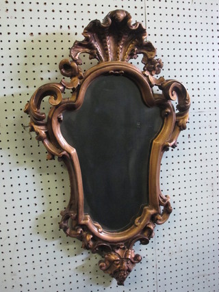 A shaped plate mirror contained in a decorative gilt frame surmounted by a shell 29"
