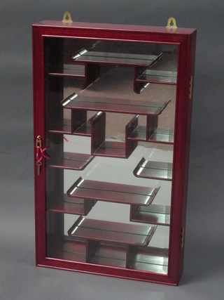 An Eastern hardwood hanging display cabinet with mirrored  back and fitted shelves enclosed by glazed panelled doors 18"