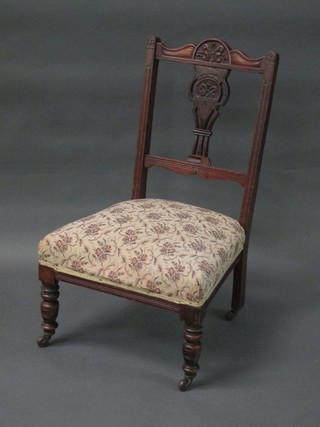 An Edwardian walnut bedroom chair with pierced vase shaped slat back