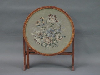 A 1930's circular oak folding fire screen/table with floral Berlin  wool work panel to the centre 21"
