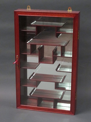 An Oriental hardwood hanging cabinet with mirrored back, fitted shelves and enclosed by a bevelled plate panelled door 18"