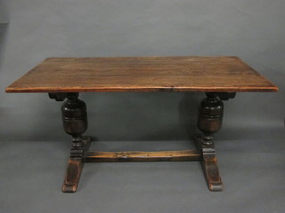 An oak refectory style dining table raised on bulbous turned  supports with H framed stretcher 60"