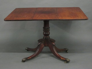 A 19th Century rectangular snap top breakfast table raised on a  pillar and tripod base ending in brass paw feet 43"