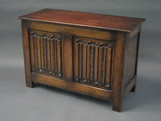 An oak coffer with hinged lid and linen fold decoration 36"