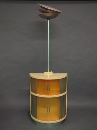 An Art Deco cream painted revolving cabinet incorporating a standard lamp  ILLUSTRATED