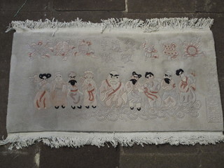 A white ground Chinese carpet decorated figures and with  characters 55" x 30"