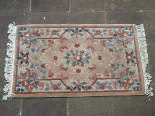 A peach ground and floral patterned Chinese rug 60" x 36"