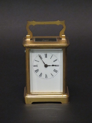 A 19th Century French 8 day carriage clock with enamelled dial  and Roman numerals contained in a gilt metal case