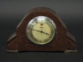 A 1930's Art Deco mantel clock with silvered dial and Arabic  numerals contained in an oak arch shaped case by Smiths
