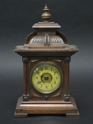 A 19th Century Continental bracket clock with paper dial and  Arabic numerals contained in a carved walnut case 6 1/2"