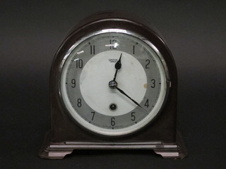 An Art Deco 8 day mantel clock with silvered dial and Arabic  numerals by Smiths contained in an arched brown Bakelite case