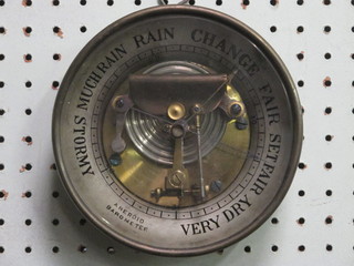 An aneroid barometer contained in a circular gilt metal case 7"