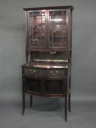 An Edwardian mahogany Chippendale style bijouterie display cabinet, the upper section fitted shelves enclosed by astragal  doors, the bow fronted base fitted a drawer above a double  cupboard enclosed by glazed panelled doors, raised on splayed  feet 30"