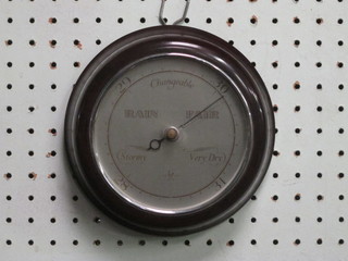 An aneroid barometer with silvered dial contained in a circular brown Bakelite case 14"