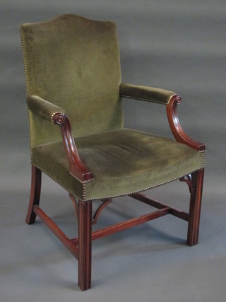 A Georgian style mahogany library chair upholstered in green material, raised on square supports with H framed stretcher