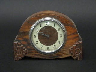 A 1930's bedroom timepiece with silvered dial and Arabic numerals contained in an oak arch shaped case by Enfield 7"