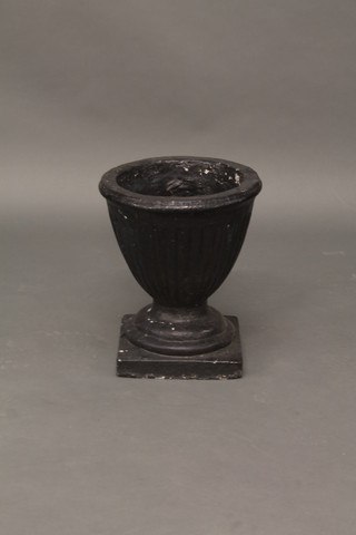 A black painted globular shaped and fluted garden urn, raised on  a square base 14 1/2"