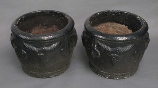 A pair of circular black painted garden urns with swag decoration  15"