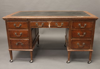 An Edwardian oak kneehole pedestal desk with inset writing surface, the base fitted brushing slides above 1 long and 6 short  drawers, raised on squared tapering supports 55"