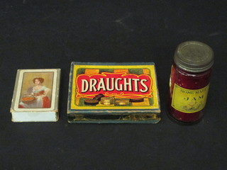 A humerous trick bottle of jam, a set of wooden draughts and a  set of Frenchman playing cards